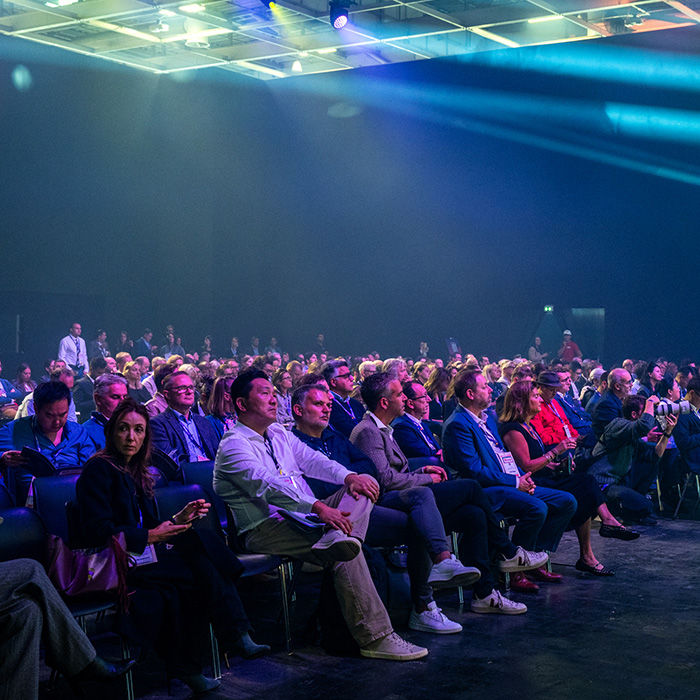 Audience seated in a room and attending a keynote speech
