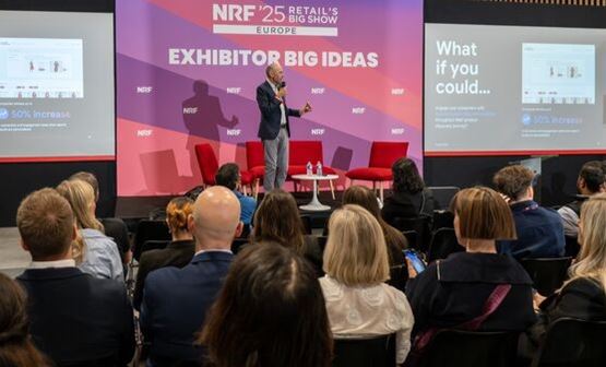 Homme tenant un micro devant un écran avec les mots Exhibitor Big Ideas