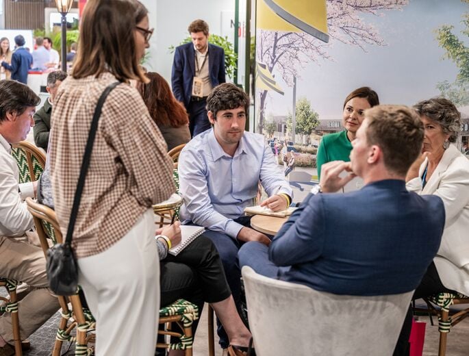 Discussion entre professionnels lors du salon SIEC 2025, avec plusieurs participants assis autour d’une table dans un espace d’échange et de networking.
