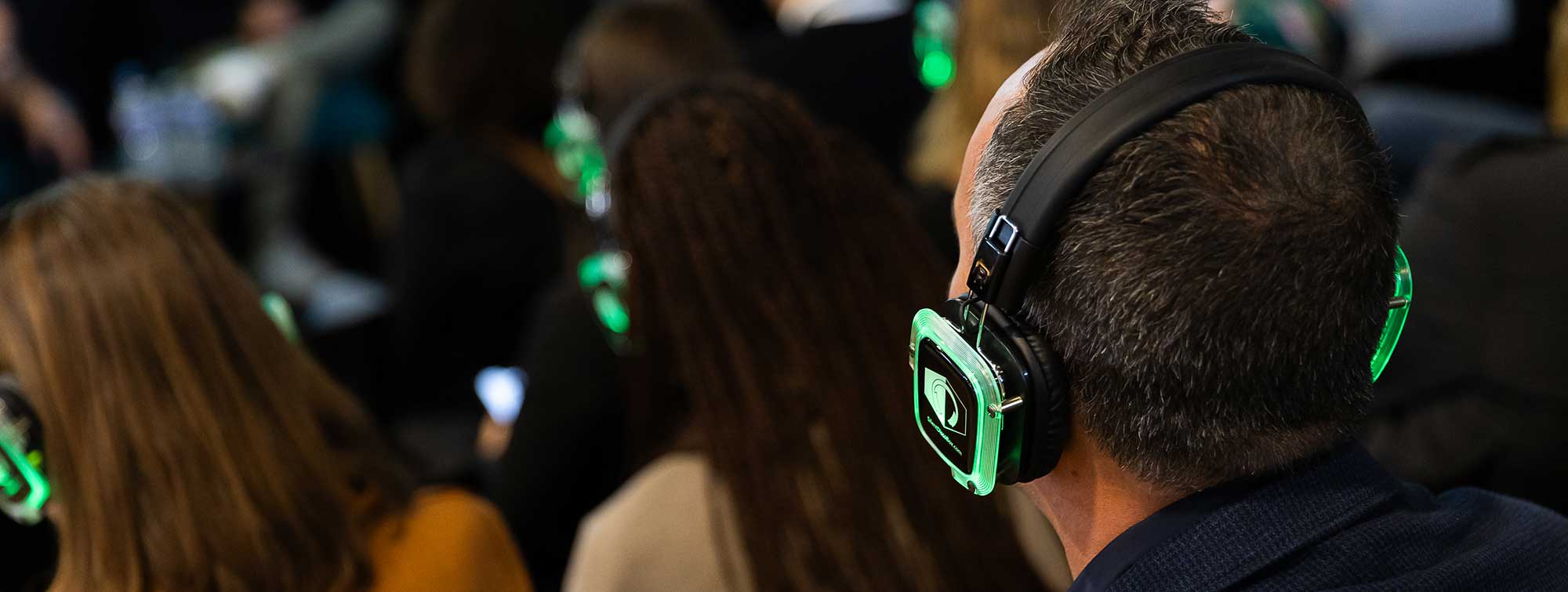 Participants portant des casques lumineux lors d'une conférence au salon.