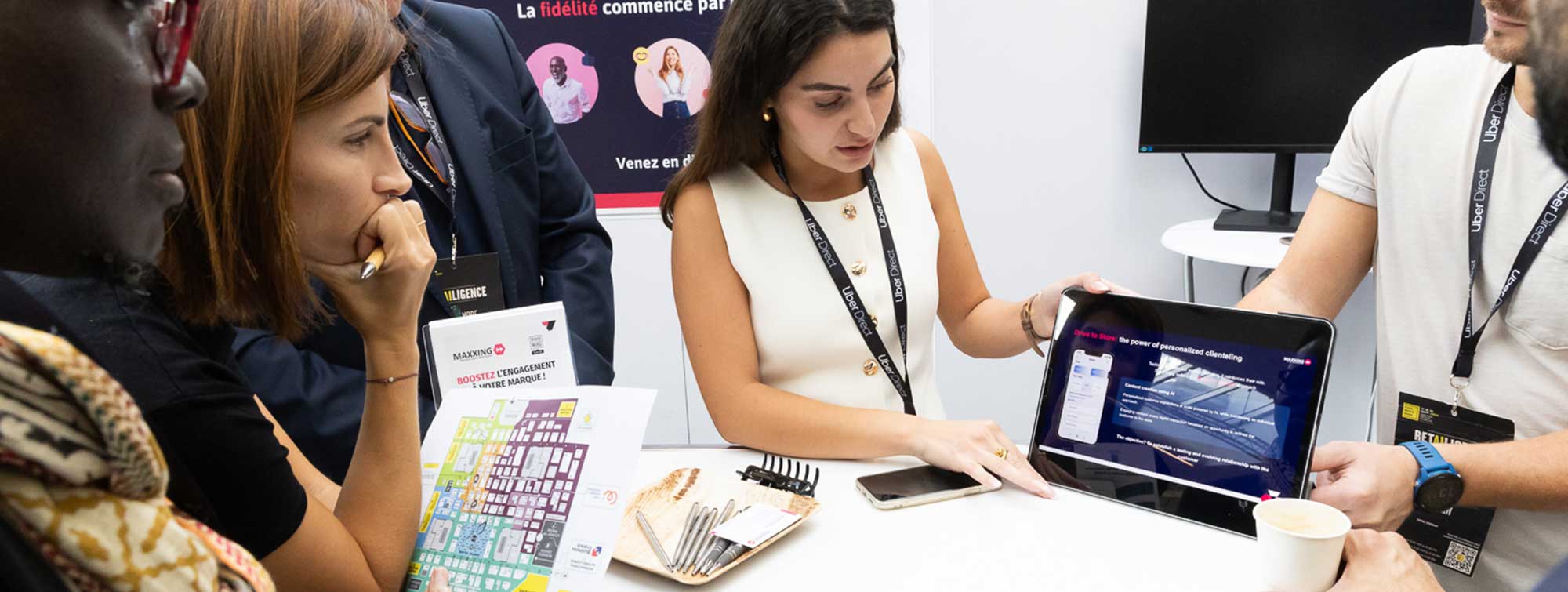 Présentation d'une solution digitale sur tablette à un groupe de participants lors du salon.