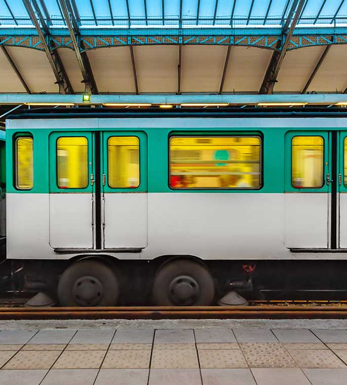 Rame de métro parisien dans une station avec une verrière moderne.